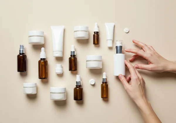 Hand removing a product from a skincare routine lineup.
